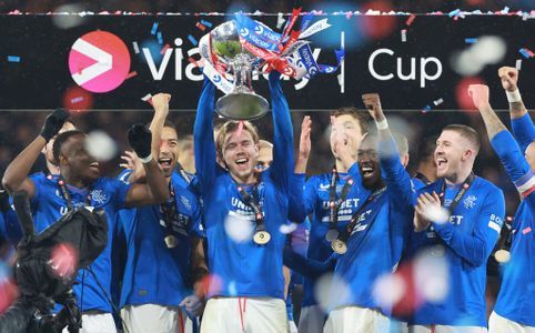 Todd Cantwell holding Scottish League Cup above head with team mates.